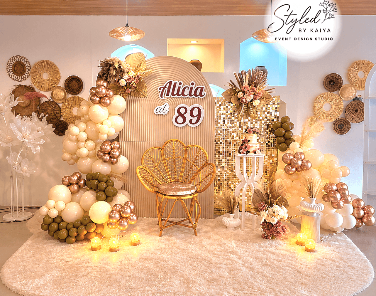 Alicia at 89 birthday celebration boho rattan chair and gold palm leaf styling