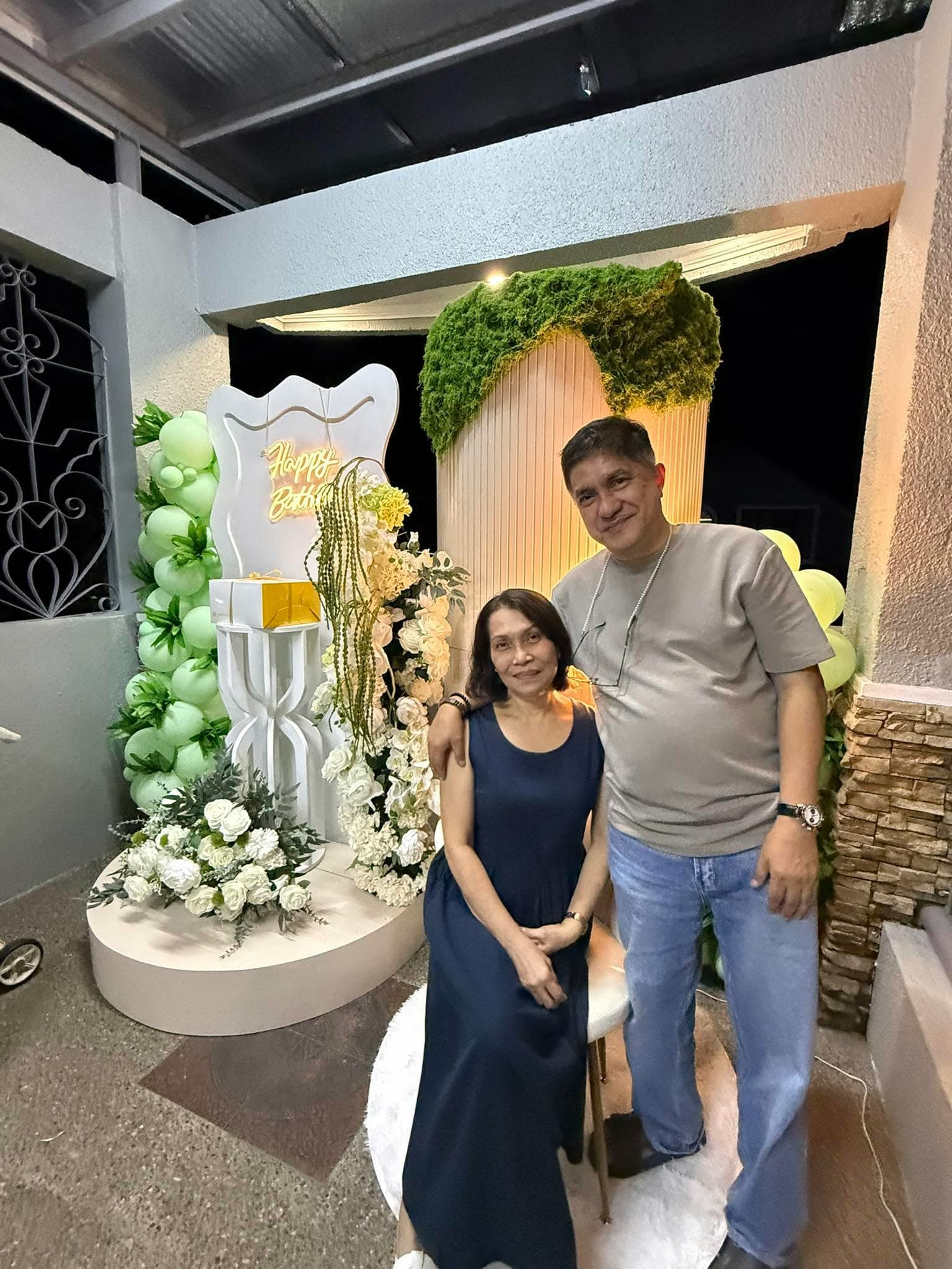 Intimate garden birthday celebration with moss arch and Happy Birthday neon sign