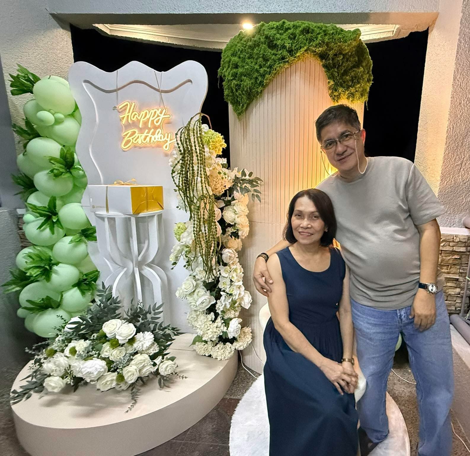 Couple celebrating at a lush green garden-themed birthday setup