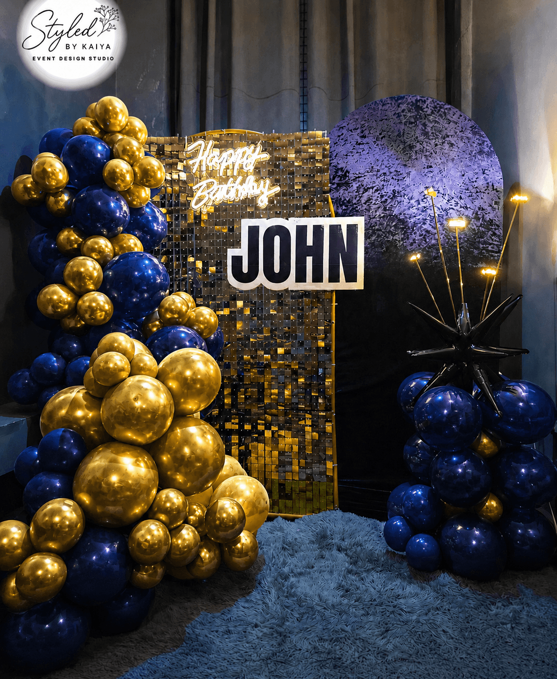 John's birthday celebration gold and navy balloon backdrop with Happy Birthday neon
