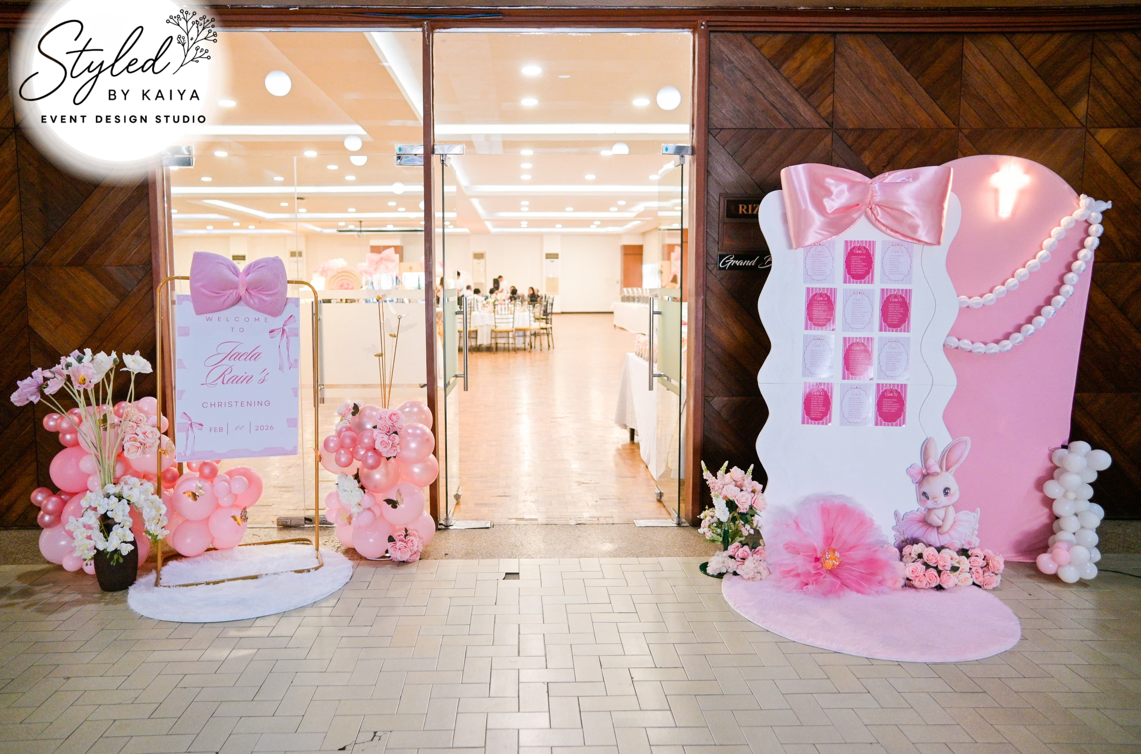 Jaela Rain christening venue entrance with dress-shaped seating chart and balloon decor