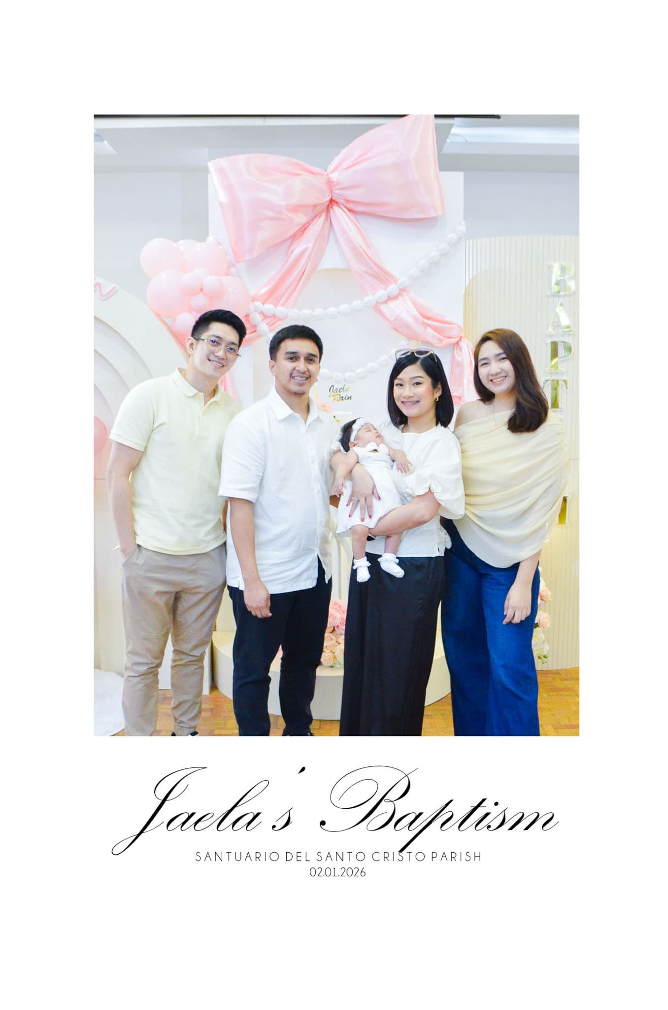 Family gathered at the pink bow backdrop for Jaela Rain's baptism celebration