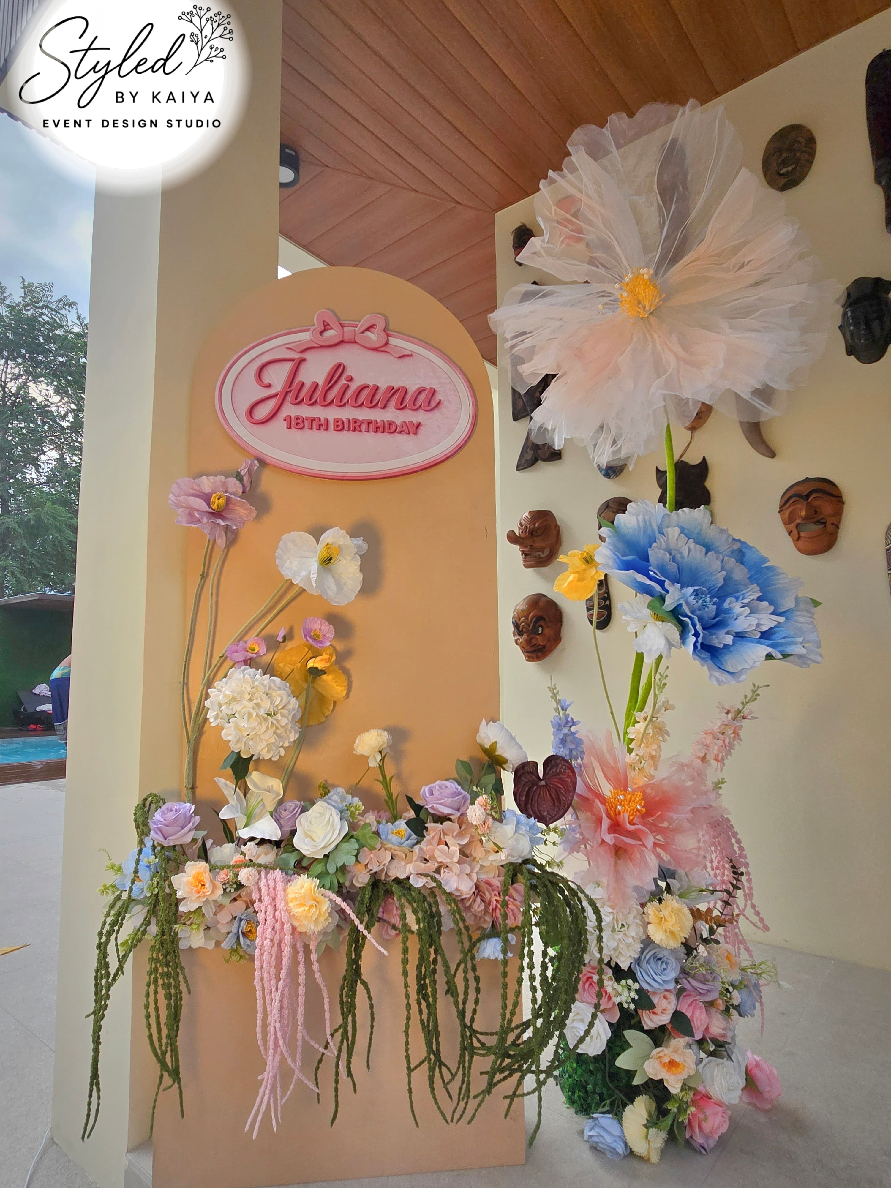 Juliana's 18th birthday colorful flower arrangement wall at venue entrance