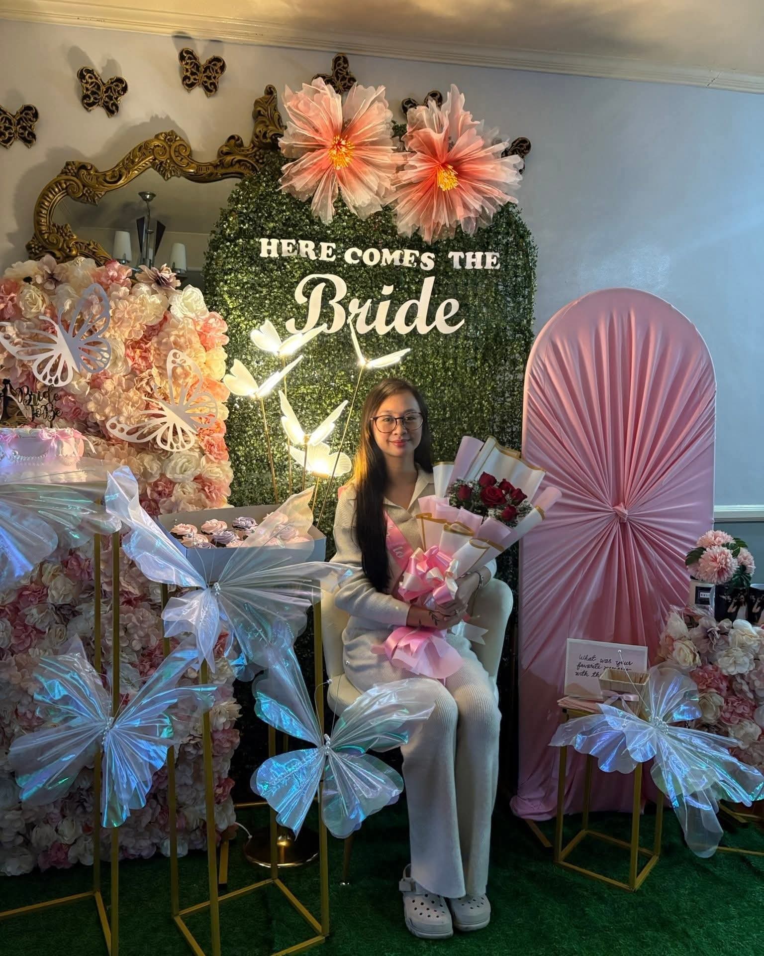 Bride-to-be seated at the floral bridal shower photo booth
